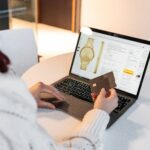 a woman sitting at a table using a laptop computer